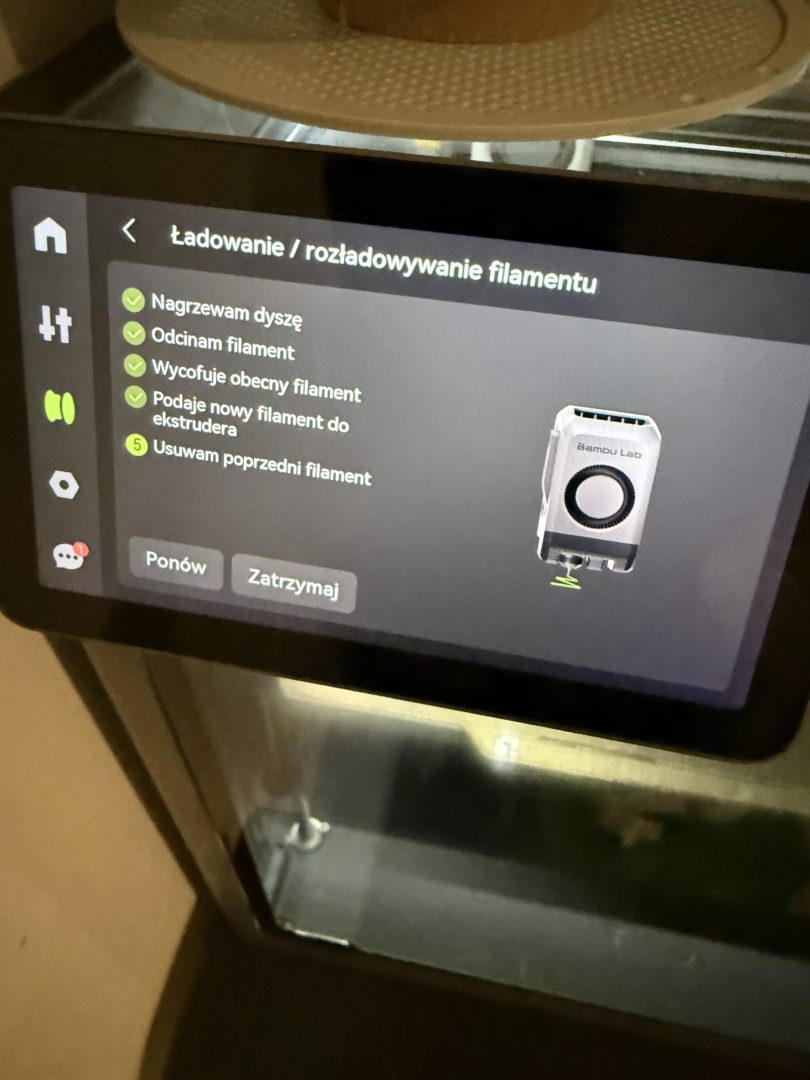 Ekran Bambu Lab P2S pokazujący automatyczne ładowanie i rozładowywanie filamentu przez system AMS