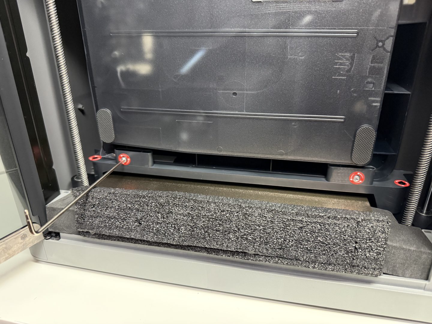 Zabezpieczony śrubami moduł AMS widoczny od dołu wewnątrz komory drukarki Bambu Lab P2S