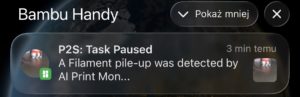Powiadomienie z aplikacji Bambu Handy o wstrzymaniu wydruku na drukarce Bambu Lab P2S z powodu wykrycia nawarstwienia filamentu przez AI