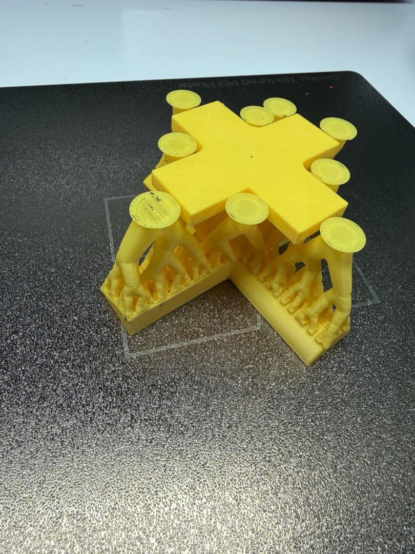 Widok od spodu modelu z PLA po zdjęciu ze stołu, przed usunięciem podpór na Bambu Lab P2S